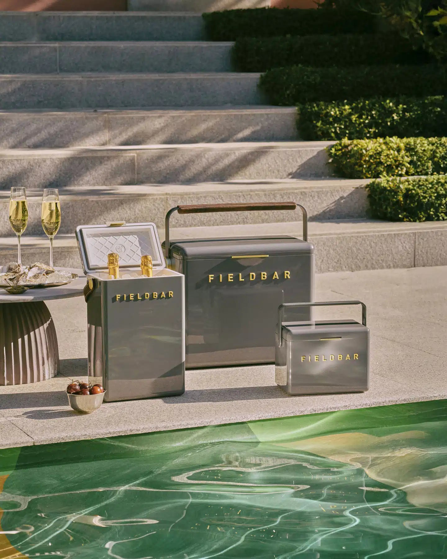 Outdoor setting with Fieldbar coolers and glasses by a poolside.
